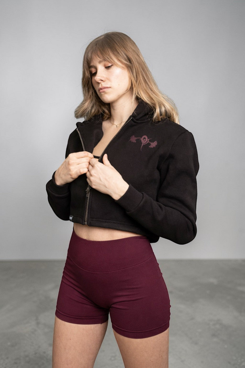 OverPower Strength Wear black cotton fleece crop zip-up hoodie with custom metal zipper and graphic detail.