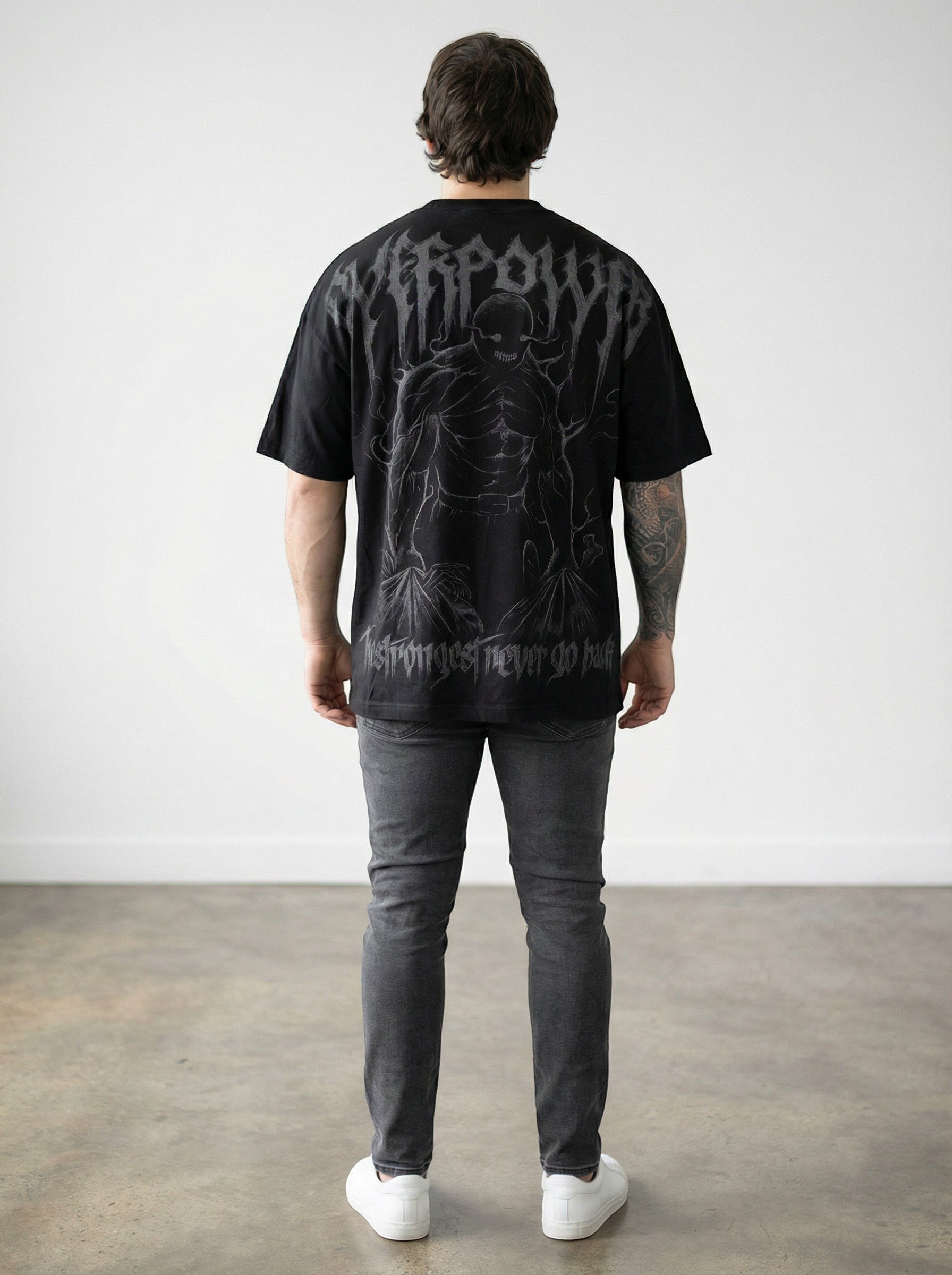 OverPower Strength Wear black oversized tee with a graphic creature and text "The Strongest Never Go Back".