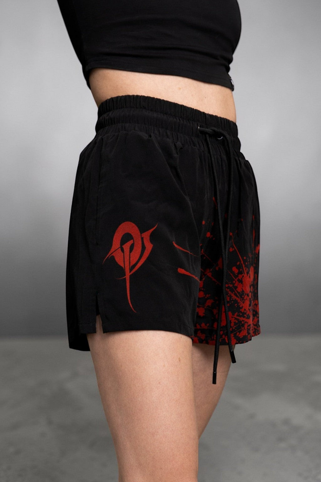 OverPower Strength Wear black unisex MMA shorts with red graphic print and blood splatter design. Nylon/spandex blend.